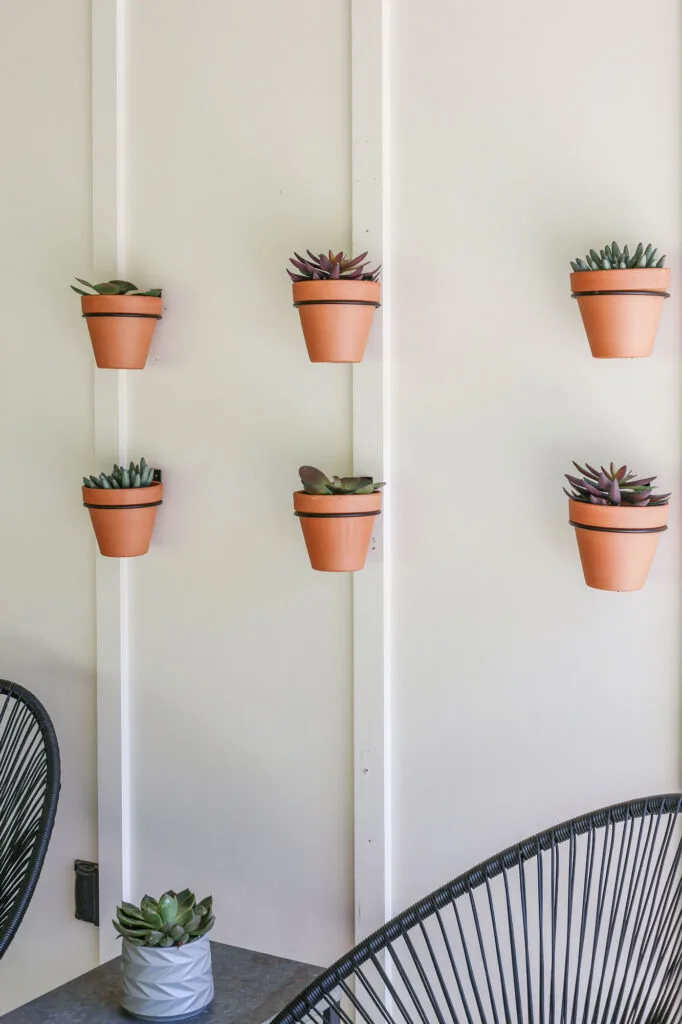 diy gallery wall of terracotta pots on exterior white walls of modern farmhouse