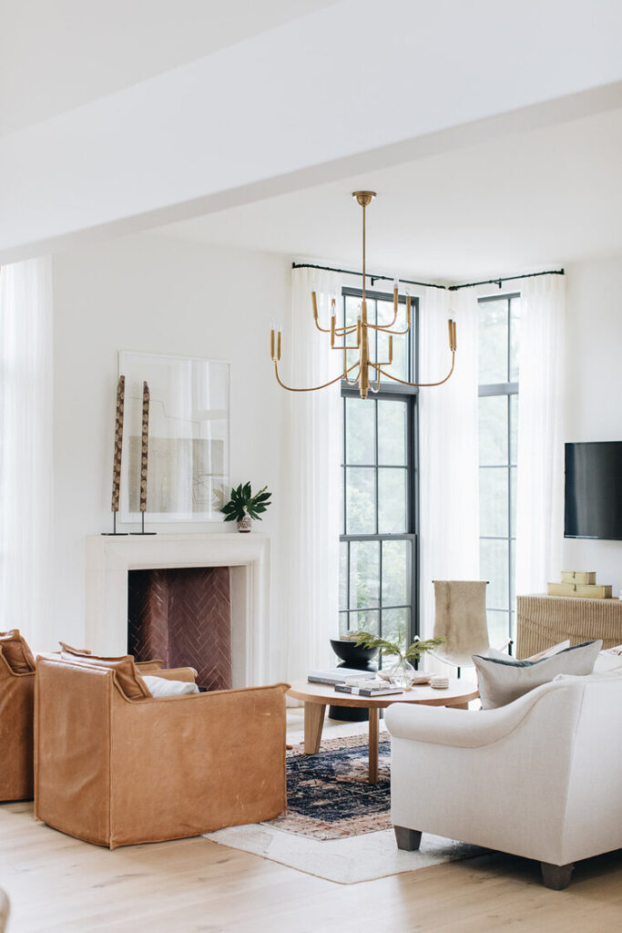 white living room with brown leather chairs