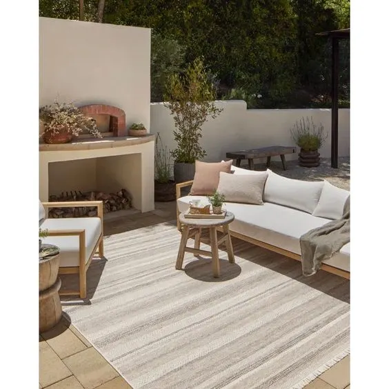 outdoor patio decorated with neutral furniture and rug