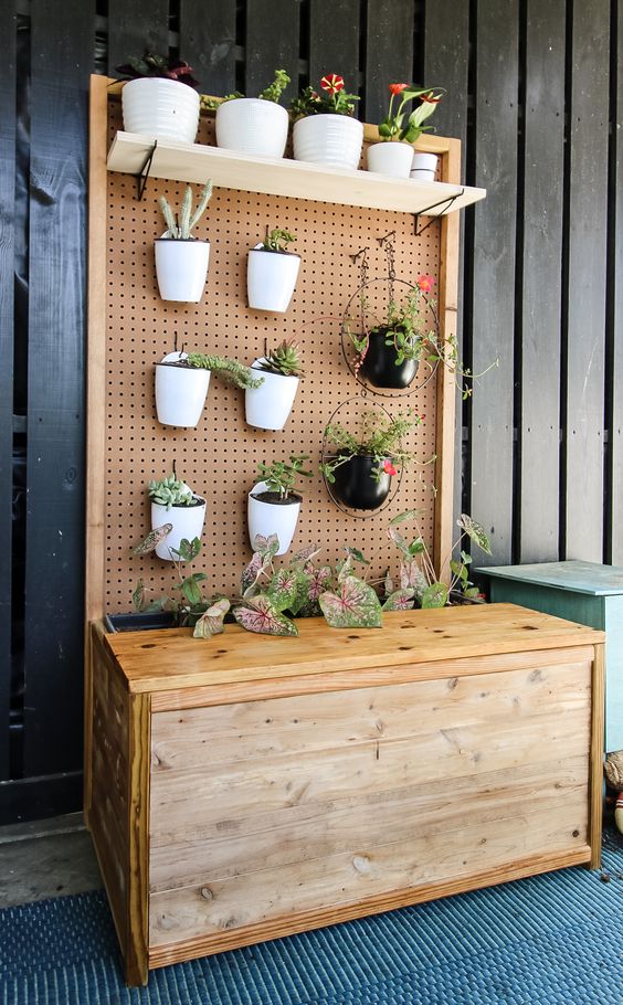 diy plant wall with  pots of succulents and cactus made from peg board
