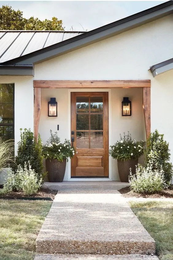 modern farmhouse porch with wooden front door and copper planters 