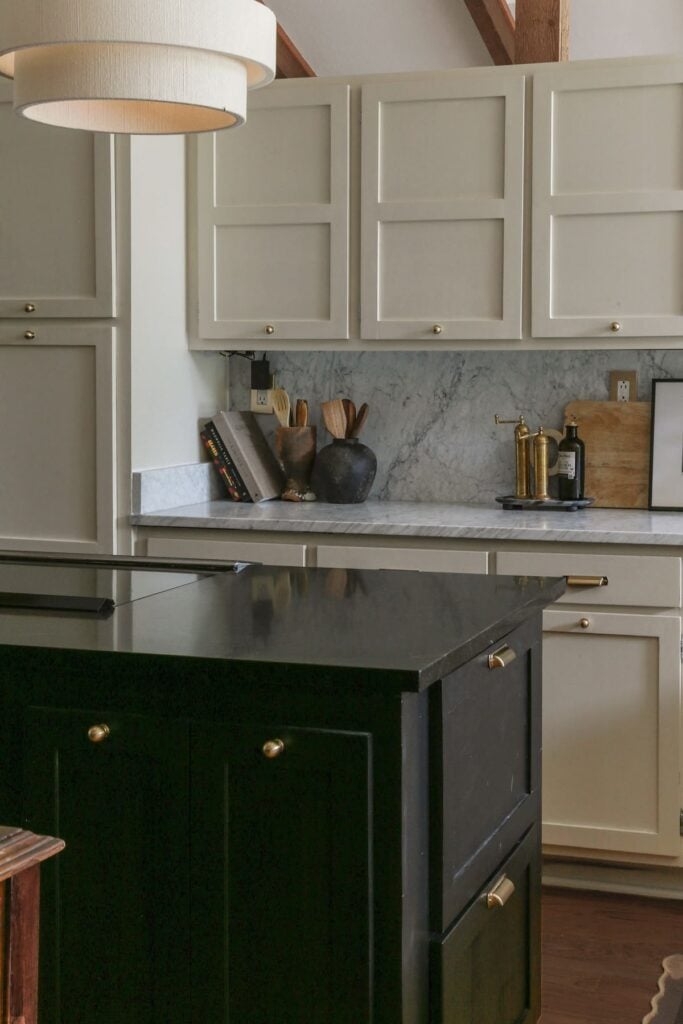 benjamin moore natural cream cabinets paired with honed Carrara marble in moody dark kitchen 