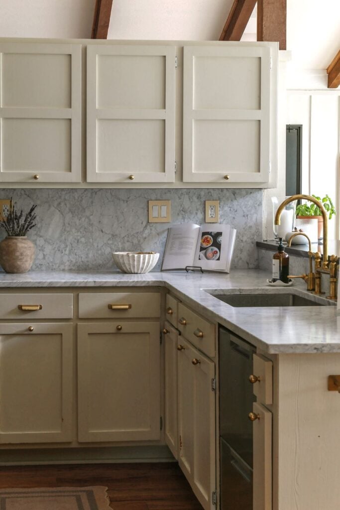 kitchen cabinets painted with natural cream by benjamin moore paired with honed carrara marble counters and backsplash