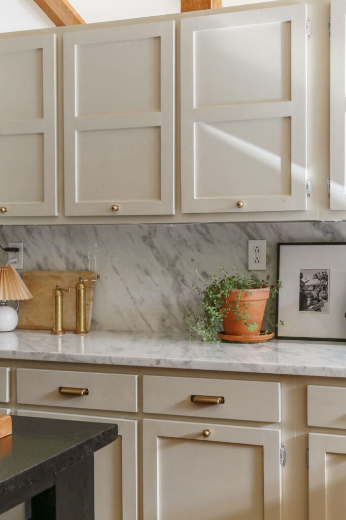 natural cream on cabinets with marble countertops and brass hardware