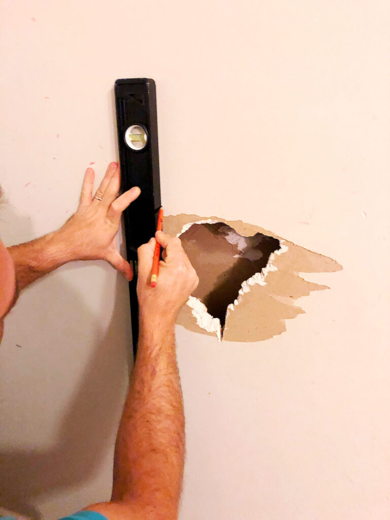 measuring hole in drywall to make proper cuts for sheetrock patch
