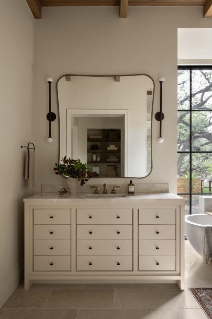 bathroom cabinets painted in Natural Linen by Sherwin Williams with greige wall color and matte black hardware