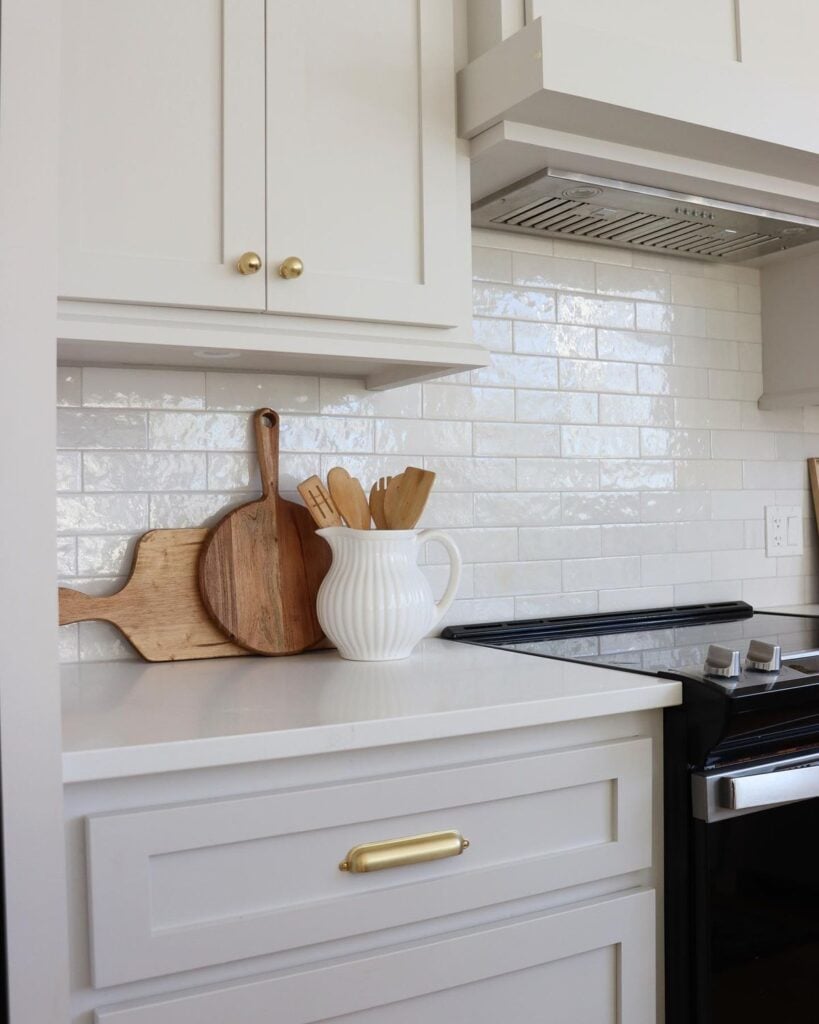 kitchen cabinets painted in pale oak greige color by benjamin moore with white countertops and backsplash