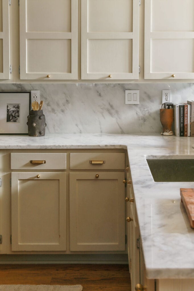 natural cream kitchen cabinets by benjamin moore paired with white marble countertops and backsplash 