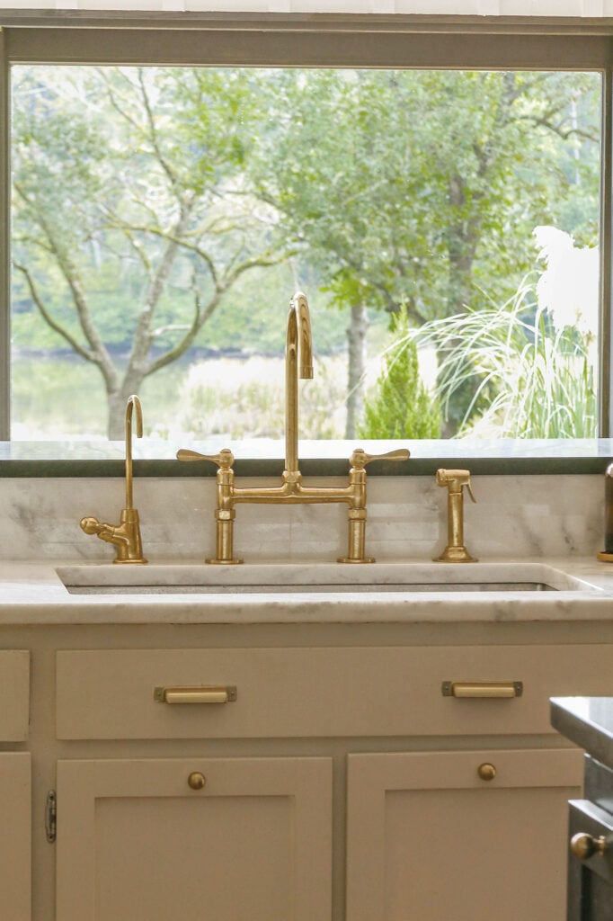 marble countertops with unlacquered brass faucet and hardware