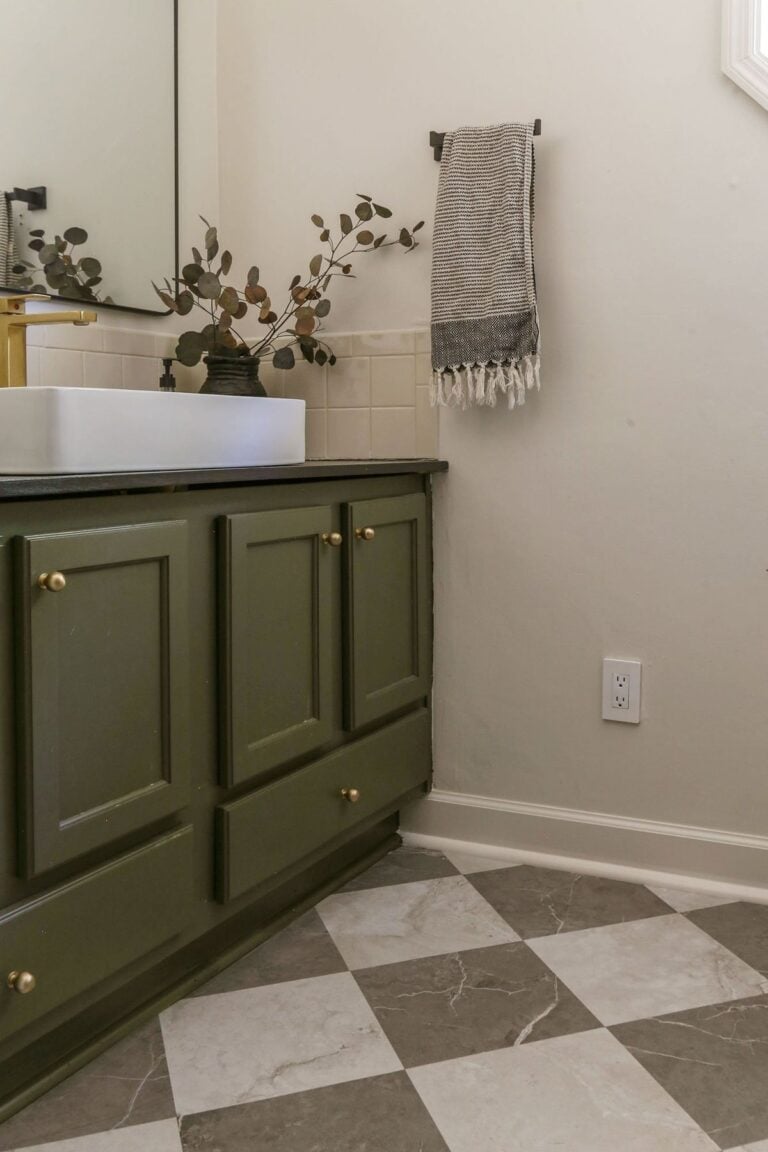 vinyl peel and stick tile floors in a checkerboard pattern installed in a bathroom with dark olive green vanity