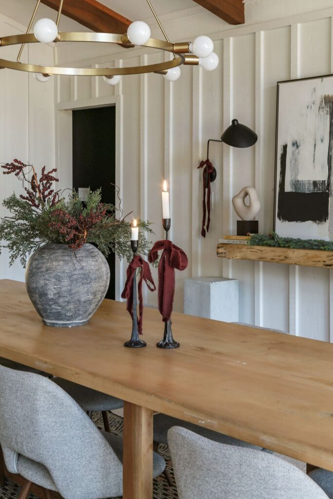 modern minmal dining room decorated for christmas with burgundy accents, ribbon and greenery