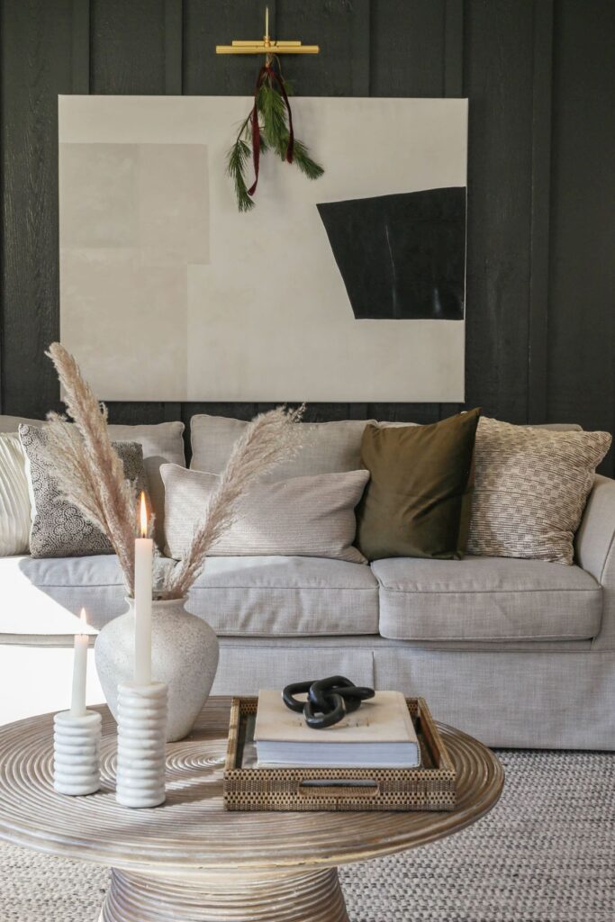 modern minimal living room with burgundy christmas decor and velvet green pillows 
