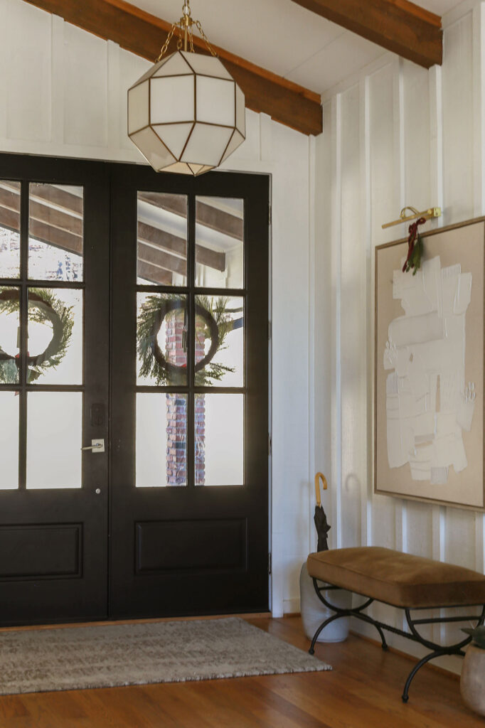 modern organic foyer decorated for christmas with burgundy ribbon and wreaths