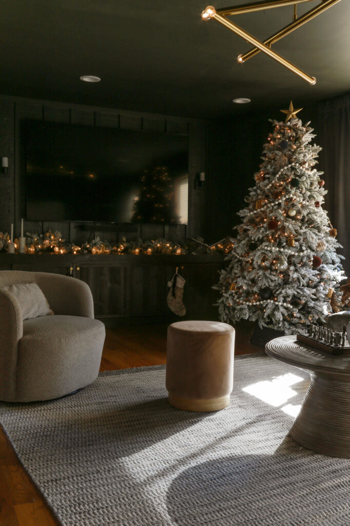 black moody modern  living room decorated with flocked christmas tree and garland