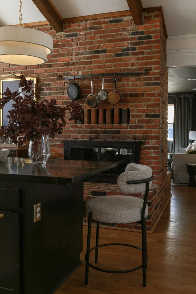kitchen with brick wall and  cabinets painted in Tricorn Black by Sherwin Williams