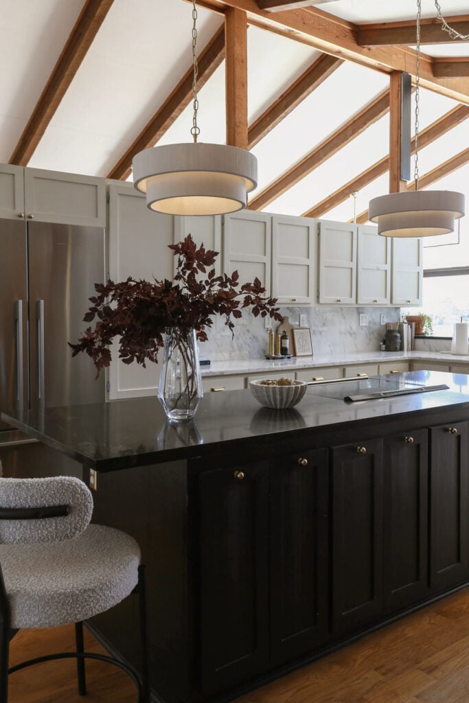 kitchen island painted in Tricorn Black paired with brass knobs 