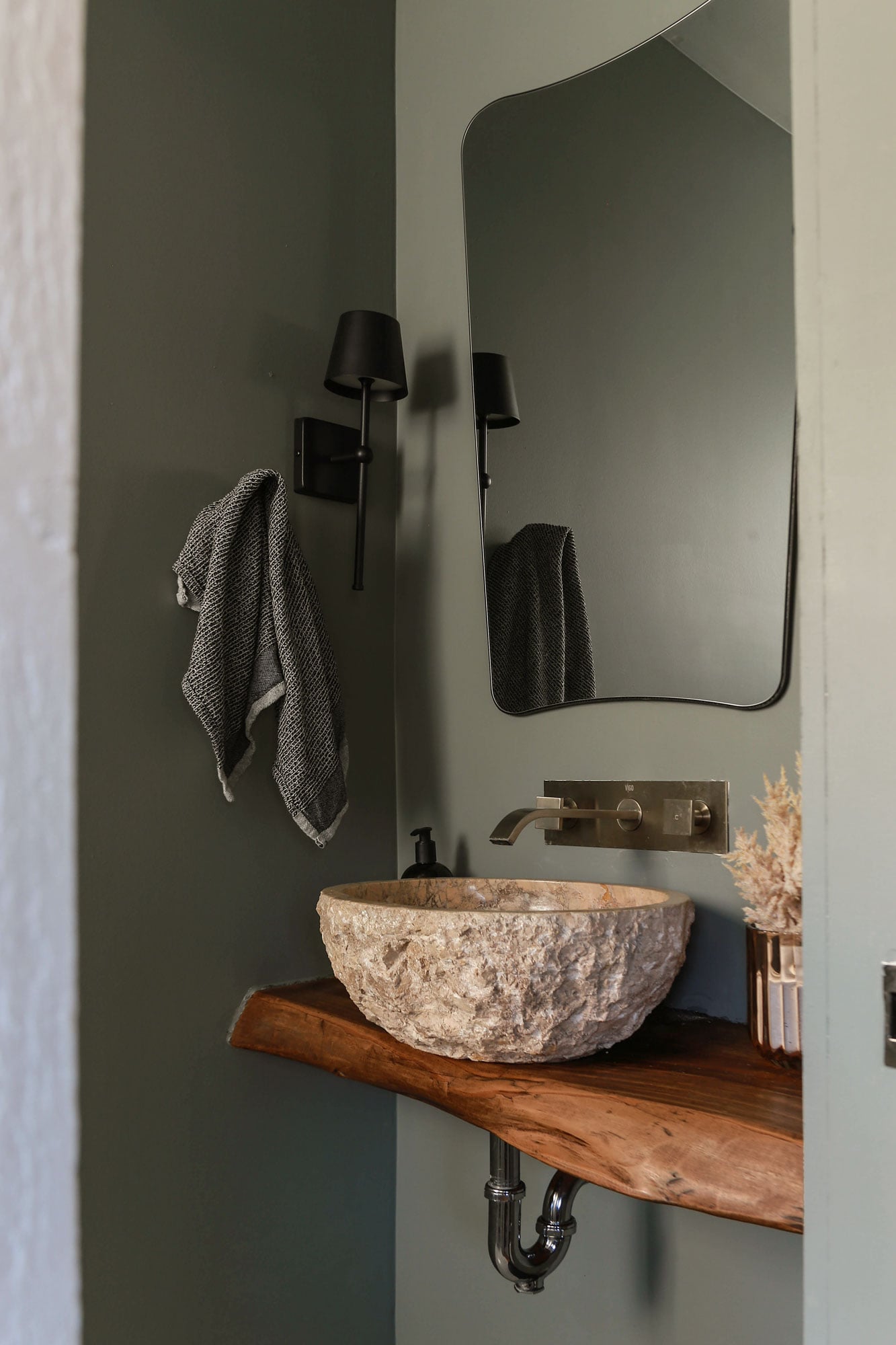 moody grey-green powder room with floating wood vanity and stone sink