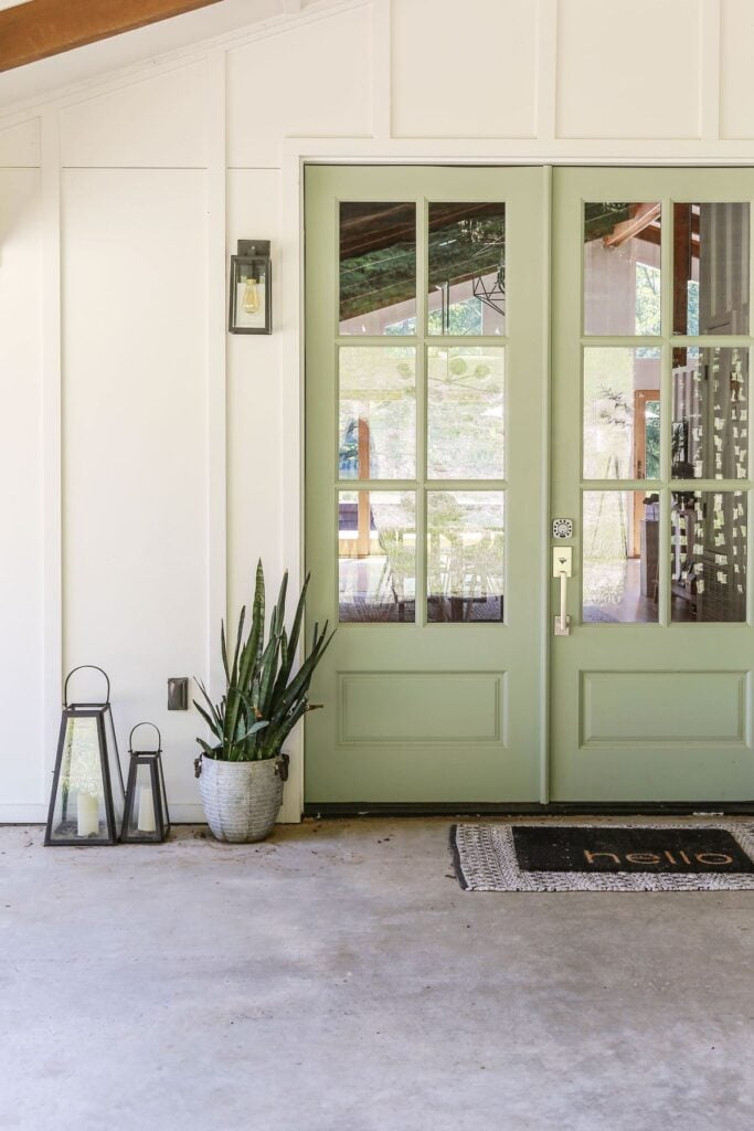 diy painted front door with a charming sage green paint color paired with white modern farmhouse siding 