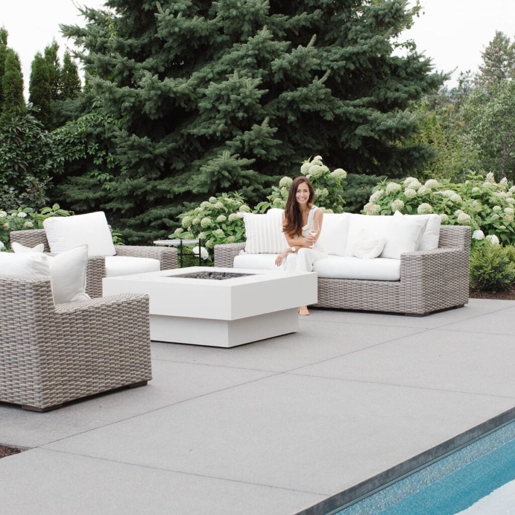 modern sofas and fire pit next to pool