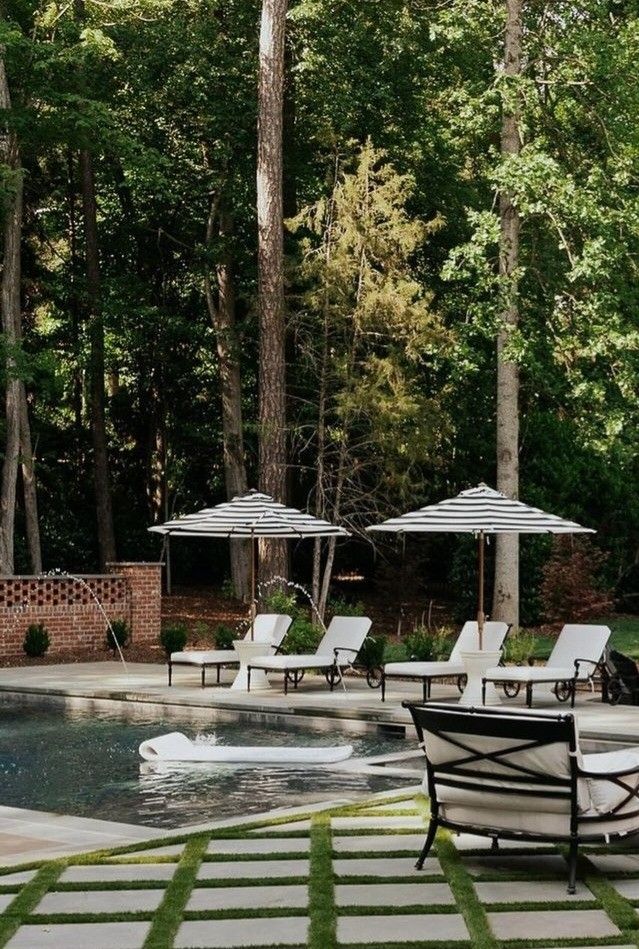 4 chaise loungers with cabana stripe umbrellas between each set by in gunite pool