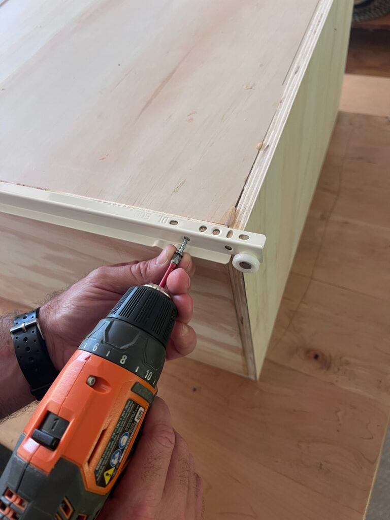 drawer sliding track system being installed on frame 