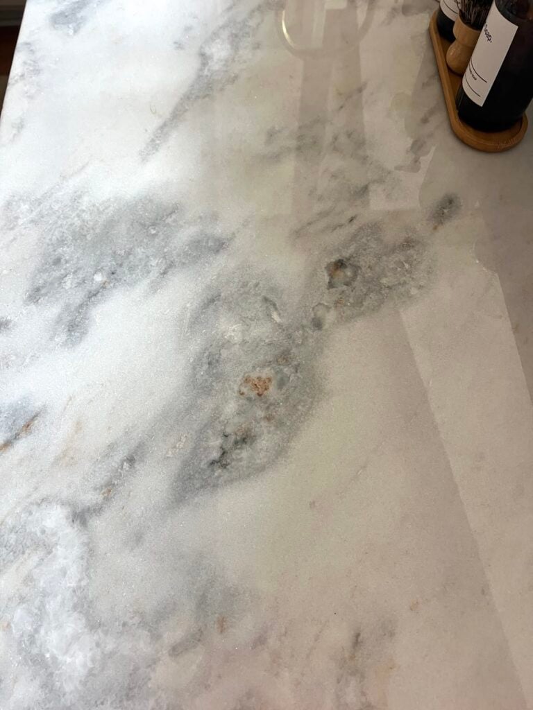 iron deposits in marble causing pink discoloration and oxidation on kitchen countertops near sink