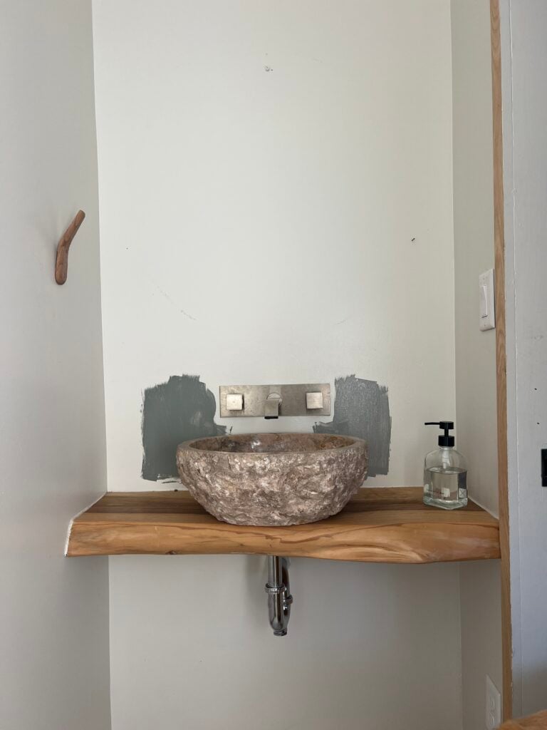samples of Duxbury Gray painted next to a stone sink and wood vanity