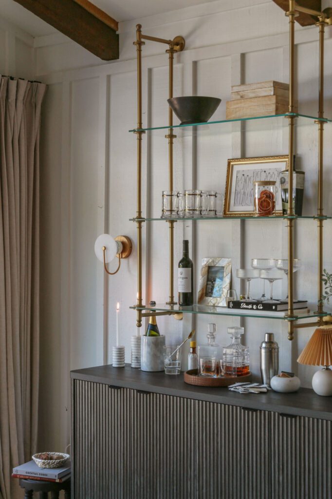 European-inspired bar shelf styling with vintage glassware on brass bistro shelves