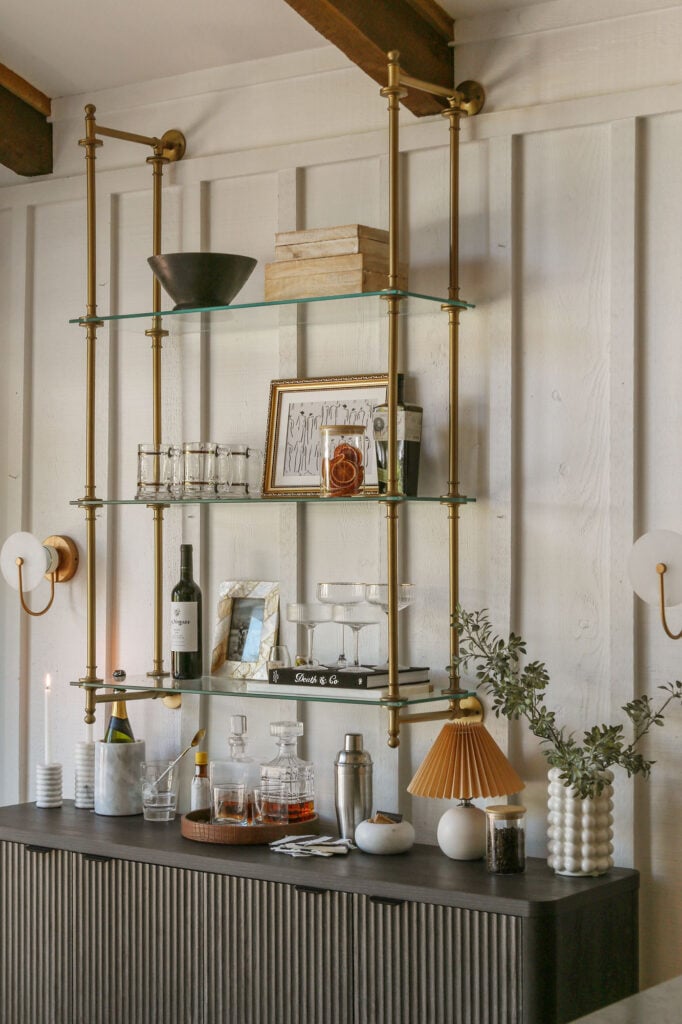 Brass bistro bar shelves styled with wine bottles, cocktail glasses, and decorative accents