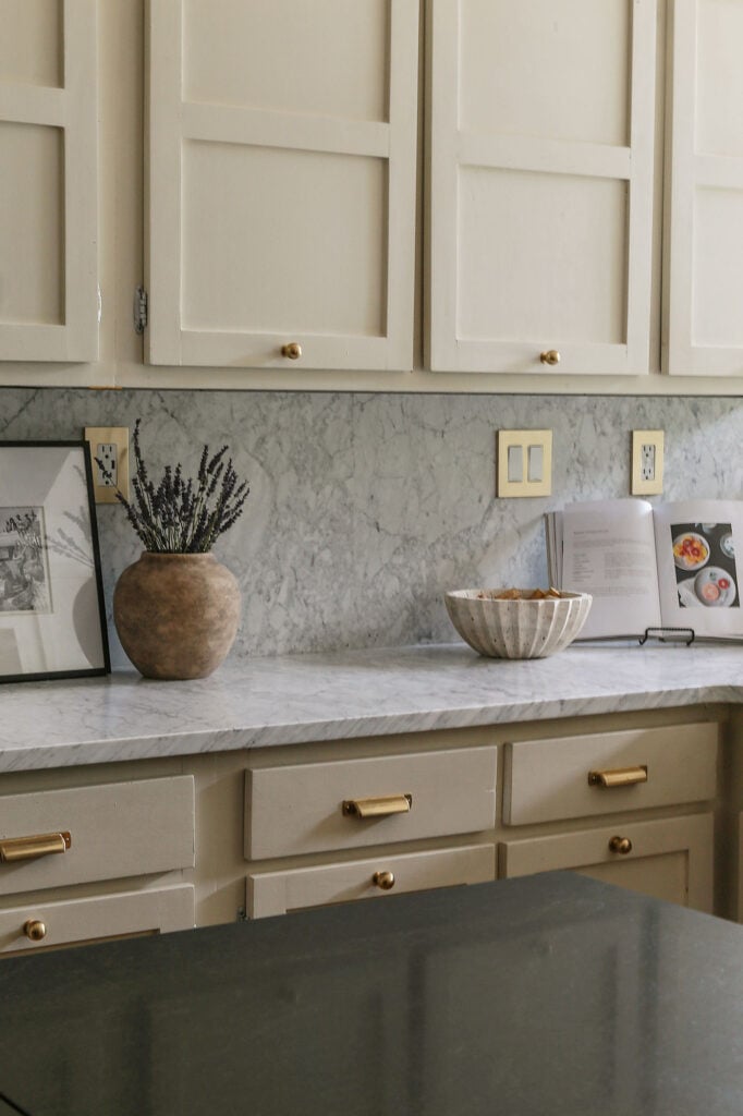 natural cream cabinets in kitchen paired with honed carrara marble countertops and backsplash 