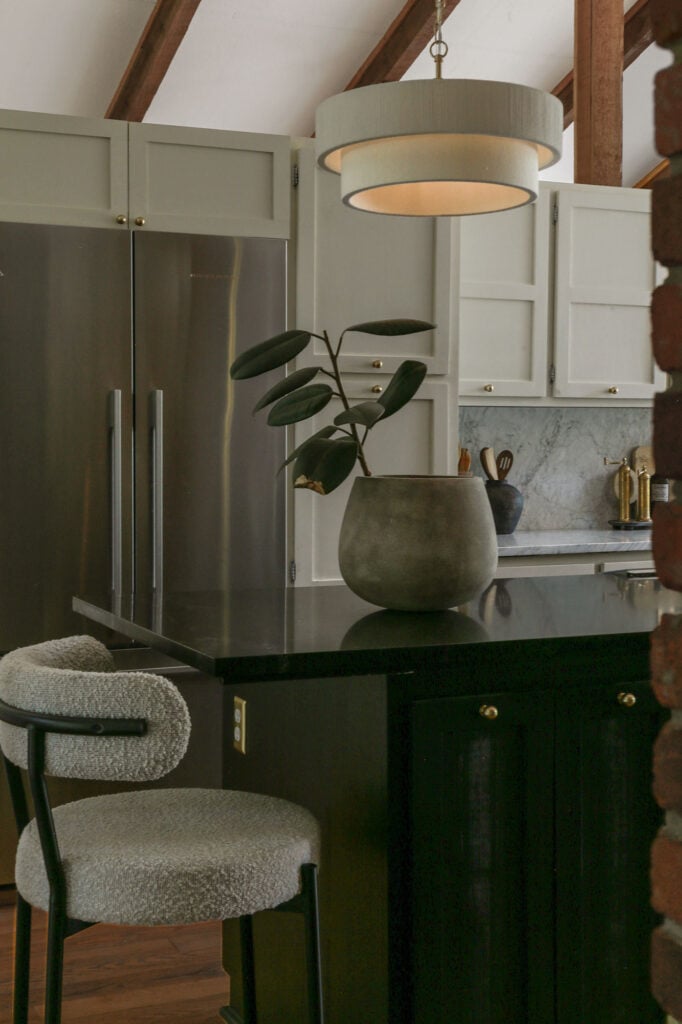 moody euro kitchen with honed carrara countertops and natural cream cabinets on perimeter with black island 
