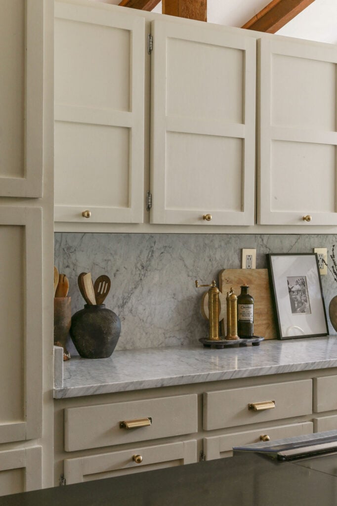 honed carrara marble backsplash and counters paired with natural cream cabinets in kitchen 