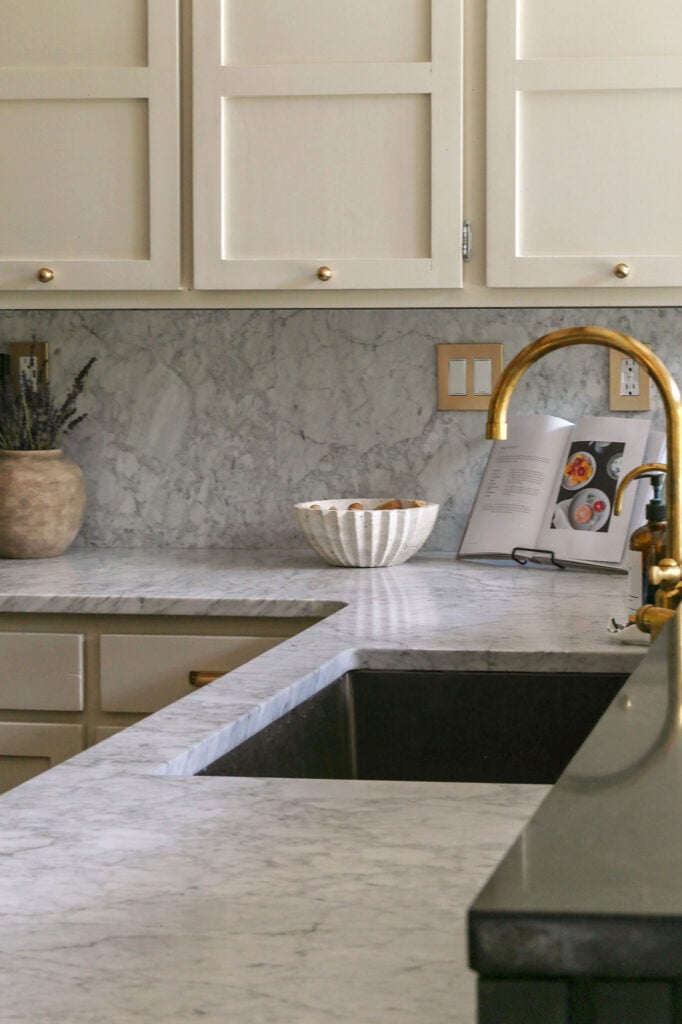 natural cream kitchen cabinets with honed carrara marble and unlacquered brass hardware