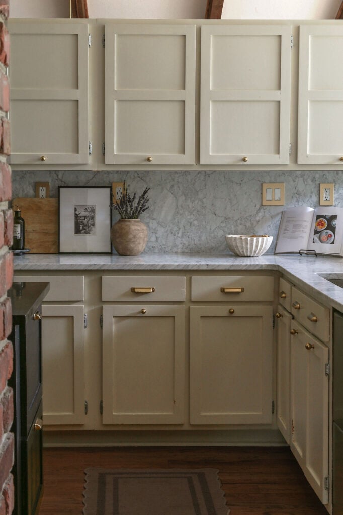kitchen with honed Carrara marble countertops and backsplash from daltile and natural cream cabinets with wood floors 