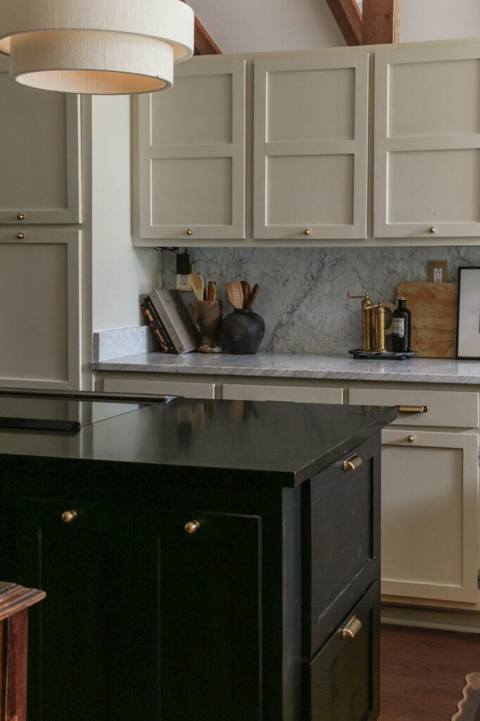 black honed granite counters on island paired with marble perimeter counters and backsplash