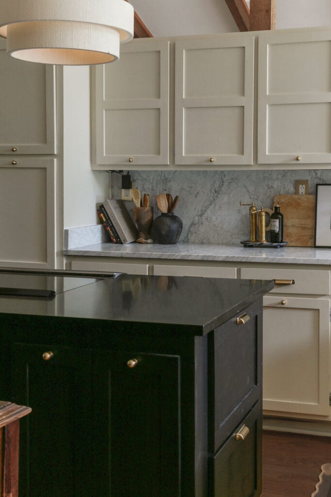 kitchen with honed Carrara marble countertops and backsplash on perimeter paired with black island and black granite in center 
