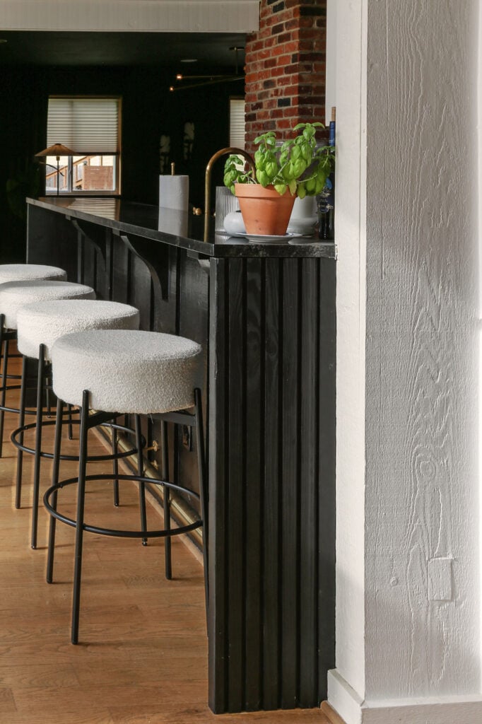 moody euro kitchen with bar and diy waterfall countertops with fluted detail 