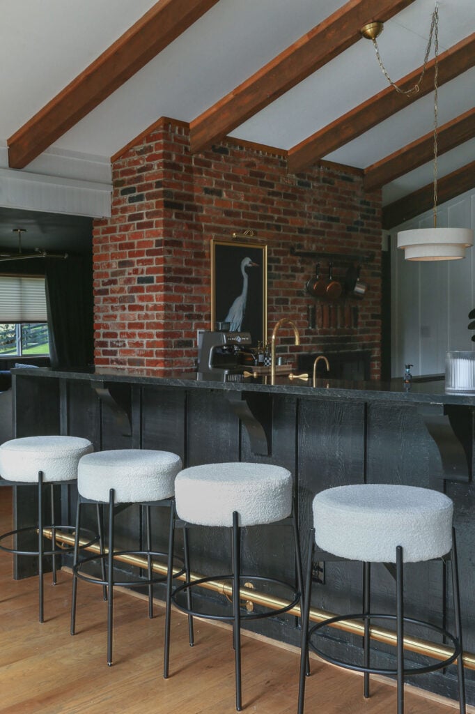 bar in kitchen with brass foot rail and waterfall countertops