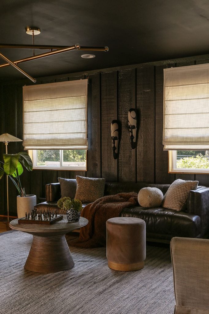 color drenched black living room with off white linen roman shades 